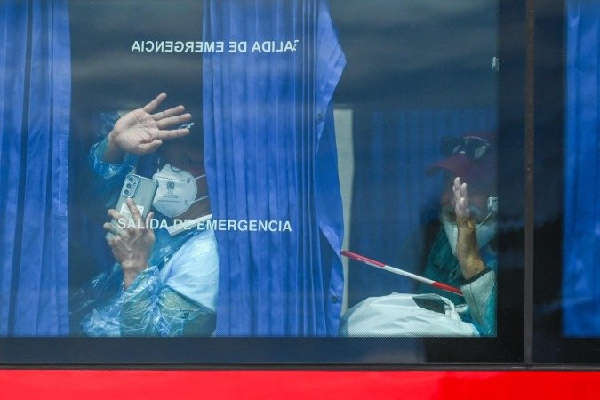 Passageiros do MV Hondius a bordo de ônibus militar, em Tenerife - (crédito: Jorge Guerrero/AFP)