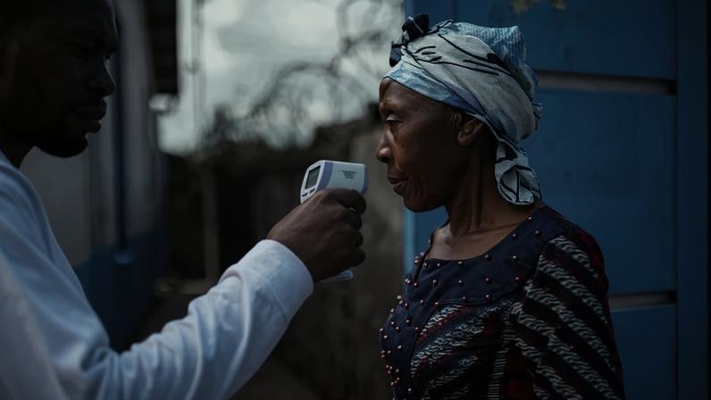 Um funcionário do Hospital CBCA Virunga verifica a temperatura de uma visitante usando um termômetro infravermelho sem contato, antes de permitir sua entrada no hospital em Goma, em 17 de maio de 2026. (Foto de Jospin Mwisha / AFP) - (crédito: AFP)