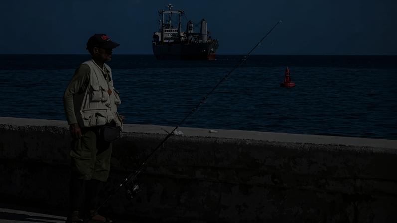 Do Malecón, pescador observa navio panamenho Asian Katra chegando a Havana com ajuda humanitária proveniente do governo mexicano - (crédito: Yamil Lage/AFP)