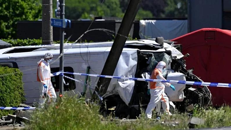 Agentes da Polícia Forense inspecionam o ônibus danificado no local do acidente, após um trem colidir com um ônibus escolar, na passagem de nível de Vierhuizen, em Buggenhout, a cerca de 20 km ao norte de Bruxelas, em 26 de maio de 2026.