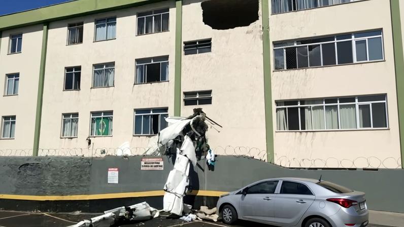Um bimotor de pequeno porte colidiu contra o edifício, em frente a um supermercado, e ficou pendurado no muro do imóvel, com parte da fuselagem no estacionamento do centro de compras - (crédito: Corpo de Bombeiros de Minas Gerais)