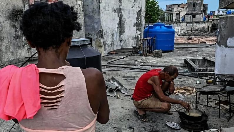 Em Havana, pessoas caminham ao lado de uma grande lixeira incendiada na noite anterior em protesto contra os prolongados apagões - (crédito: EPA/Shutterstock)