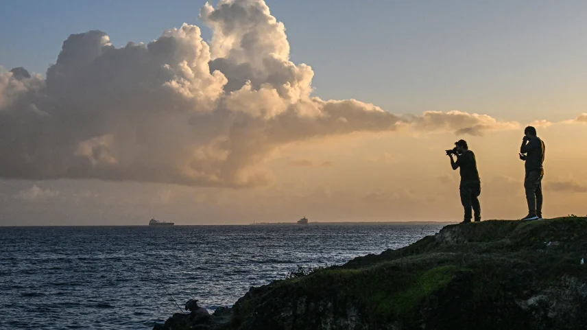 A man takes a picture of a Russian oil tanker as it arrives at the oil terminal in the port of Matanzas, northwestern Cuba, on March 31.