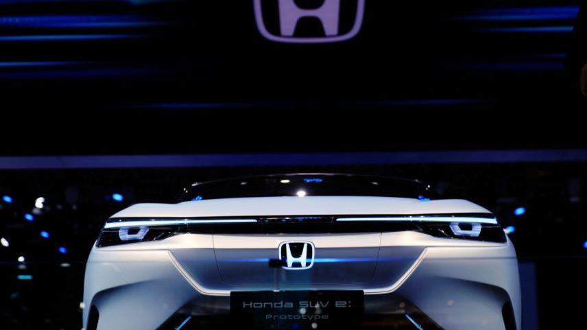 Carro-conceito Honda SUV e: Prototype branco com iluminação LED em exposição. Grande logo Honda acima.