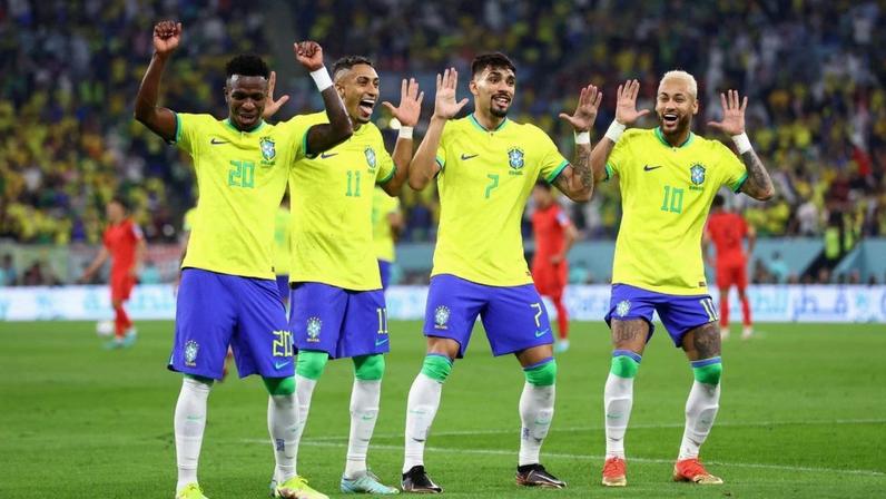 Quatro jogadores do Brasil, incluindo Neymar e Vinicius Jr., celebram em campo, com braços erguidos e sorrisos.