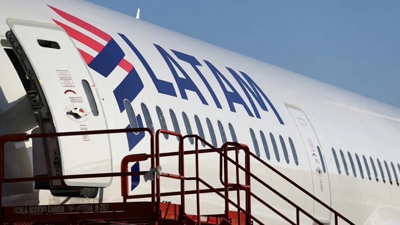 Avião LATAM com porta aberta e escada de embarque.