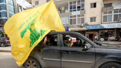 Homem gesticula enquanto segura bandeira do Hezbollah no segundo dia do cessar-fogo entre Israel e o grupo apoiado pelo Irã em Tiro, no sul do Líbano