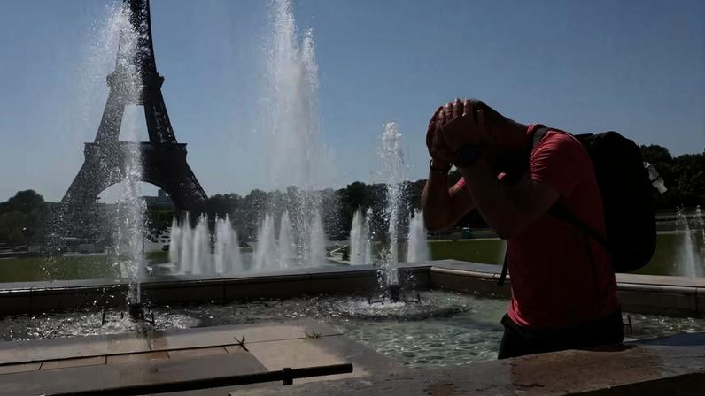 Turista se refresca em fonte perto da Torre Eiffel em meio à onda de calor na França