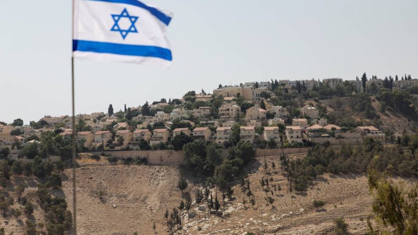 Bandeira israelense na Cisjordânia ocupada por Israel com assentamento Maale Adumim ao fundo