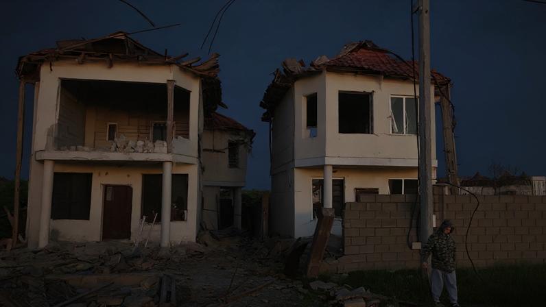 Um morador observa de perto edifícios danificados por um ataque de drone russo, próximo à cidade de Chornomorsk, na região de Odessa, Ucrânia, em 3 de maio de 2026.