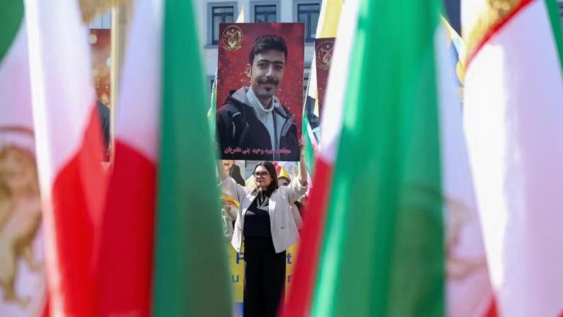 Manifestante segura foto do iraniano Vahid Bani Amerian, preso e executado no Irã, durante manifestação contra o regime dos aiatolás, em Bruxelas, na Bélgica, em abril de 2026. — Foto: Omar Havana/ Reuters