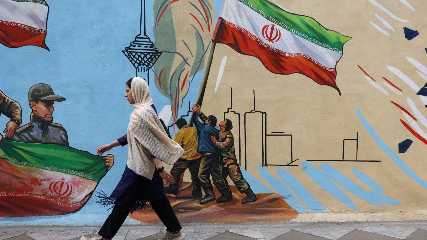 Iraniana caminha ao lado de mural com a ilustração da bandeira do Irã, em Teerã, no dia 5 de maio de 2026 — Foto: Majid Asgaripour/Wana/Reuters
