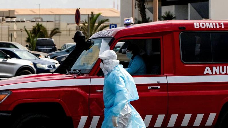 Uma pessoa com roupa de proteção caminha ao lado de uma ambulância durante a operação de evacuação de pacientes suspeitos de hantavírus, após um surto no navio de cruzeiro MV Hondius, na Praia, em Cabo Verde, em 6 de maio de 2026. REUTERS/Danilson Sequeira
