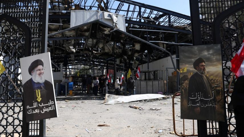 Um retrato do falecido líder do Hezbollah, Hassan Nasrallah, e do novo líder supremo do Irã, Mojtaba Khamenei, está pendurado em uma cerca perto do local de um ataque israelense ocorrido antes da entrada em vigor de um cessar-fogo temporário, nos subúrbios do sul de Beirute, Líbano
