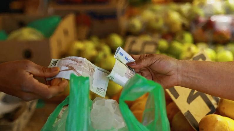 Uma cliente paga a um vendedor em uma barraca de mercado em Ciudad Juarez, México, em 15 de abril de 2026. REUTERS/Jose Luis Gonzalez/File Photo
