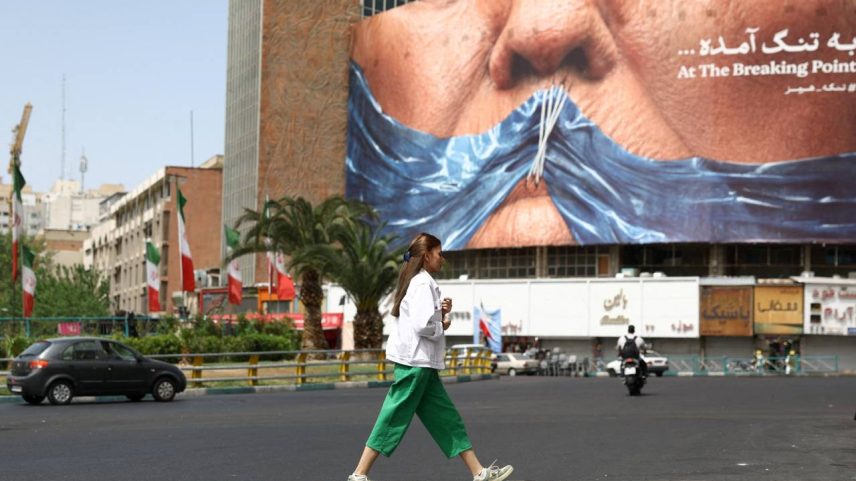 Uma mulher passa em frente a um outdoor anti-EUA que retrata o presidente americano Donald Trump e o Estreito de Hormuz, em Teerã, no Irã, em 8 de maio de 2026. Foto: Majid Asgaripour/WANA (West Asia News Agency) via Reuters