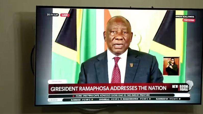 Sul-africano em Joanesburgo assiste a pronunciamento do presidente do país, Cyril Ramaphosa, nesta segunda (11/05) — Foto: REUTERS/Siphiwe Sibeko