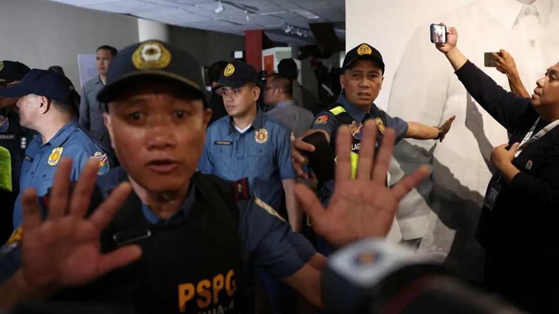 Agentes de segurança do Senado e policiais pedem aos membros da mídia que fiquem afastados após tiros serem ouvidos no Senado das Filipinas, enquanto o caos aumentava em antecipação a uma tentativa de prender um senador de alto escalão procurado pelo Tribunal Penal Internacional, em Pasay City, Metro Manila, Filipinas, 13 de maio de 2026 (Eloisa Lopez/Reuters)