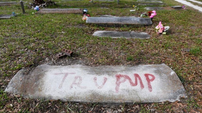 Uma lápide pichada com a palavra 'Trump', em referência ao presidente dos EUA, Donald Trump, no Cemitério Antigo de Memphis, um cemitério predominantemente afro-americano, após o local ter sido vandalizado, com 17 sepulturas e várias lápides danificadas em Palmetto, Flórida , EUA, em 14 de maio de 2026. As autoridades dizem que 'Trump' e 'DeSantis' foram pichados em vermelho em vários túmulos, enquanto a polícia continua investigando o incidente.