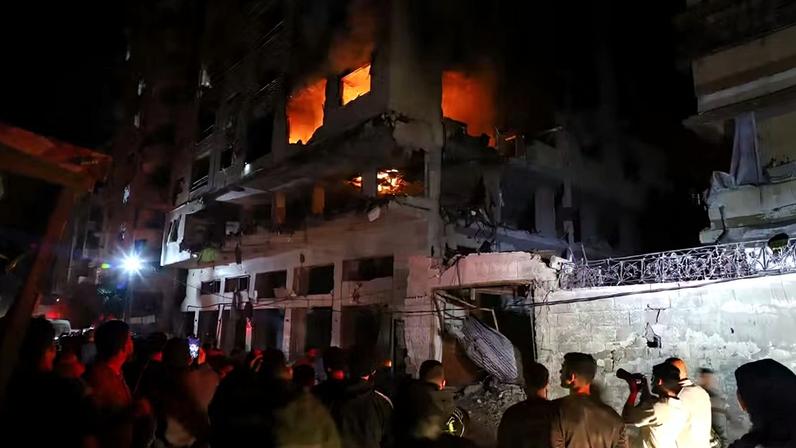 Moradores de Gaza observam edifício atingido por ataque de Israel a Izz al-Din al-Haddad, o líder militar do Hamas em Gaza