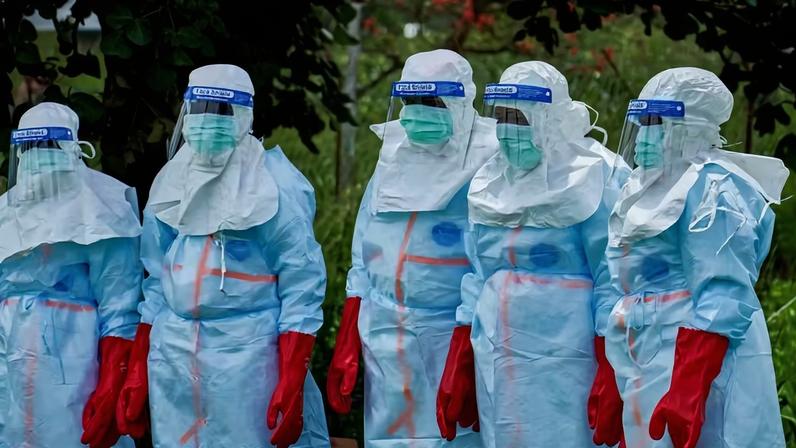 Trabalhadores da Cruz Vermelha se reúnem para desinfetar o hospital geral de Rwampara antes de lidar com o corpo de uma pessoa que morreu de Ebola na República Democrática do Congo