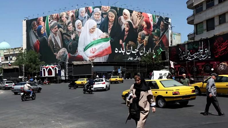 Pessoas caminham em frente a um outdoor com a imagem de cidadãos iranianos , em Teerã, Irã , 25 de maio de 2026
