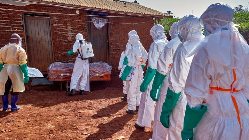 Trabalhadores da Cruz Vermelha, usando equipamentos de proteção individual (EPI), desinfetam a casa de um homem não identificado que morreu de ebola antes de removerem seu corpo, enquanto agências humanitárias intensificam os esforços para conter um novo surto de ebola envolvendo a cepa Bundibugyo, no Quartier Shuni 1, um setor residencial em Mongbwalu, Território de Djugu, província de Ituri, República Democrática do Congo