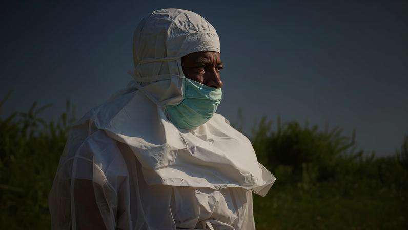 Um funcionário da Cruz Vermelha usando equipamento de proteção individual (EPI) participa do enterro do Dr. Tibenderana Katho Blaise, que trabalhava no Centro Médico Evangélico (CME) na comuna de Hoho e morreu vítima do vírus ebola