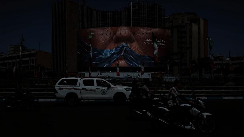 Pessoas passam por outdoor anti-EUA em Teerã 25 de maio de 2026 Majid Asgaripour/WANA via REUTERS