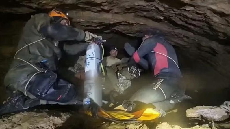 Mergulhadores orientam pessoas presas em caverna inundada durante operação de resgate no Laos. — Foto: Norrased Palasing/via REUTERS