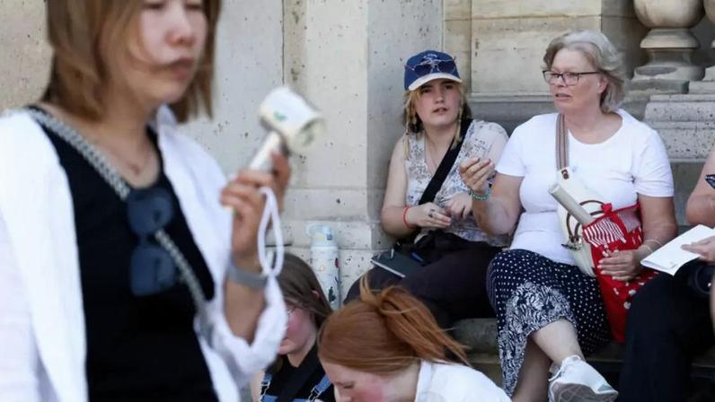 Turistas tentam se refrescar em meio a calor inédito para um mês de maio em Paris. (28/05/2026)