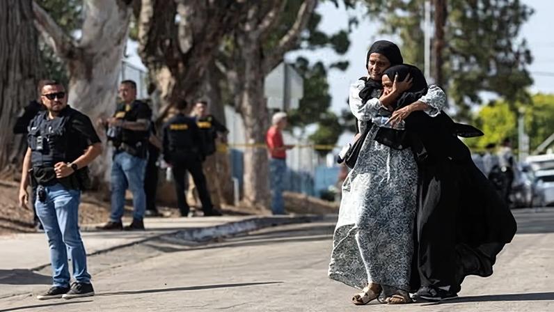 Two women embrace after the shooting at the Islamic Center of San Diego in southern California, on 18 May 2026.