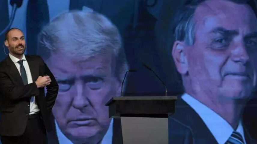 Eduardo Bolsonaro diante de uma imagem de seu pai e de Donald Trump