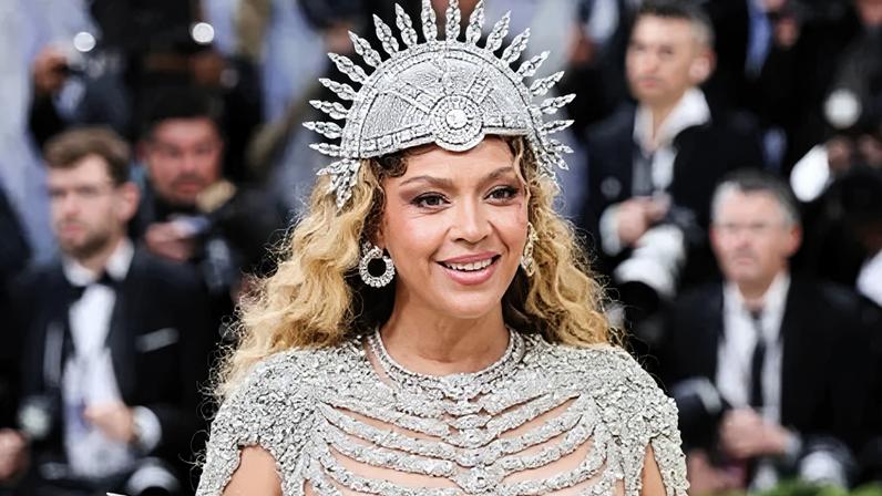 EPA US performer Beyonce poses on the red carpet for the 2026 Met Gala wearing a shimmering skeletal gown and a spherical headpiece as photographers in suits stand behind her.