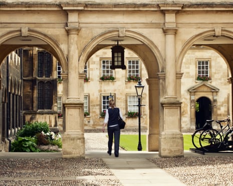 A student passing through a college campus at Cambridge University.