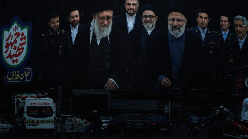 Trabalhador passa diante de outdoor com imagens de Ali Khamenei e Ebrahim Raisi, na praça Enghelab, em Teerã, em meio à continuidade das tensões entre Irã e Estados Unidos. (Foto: EFE/EPA/Abedin Taherkenareh.)