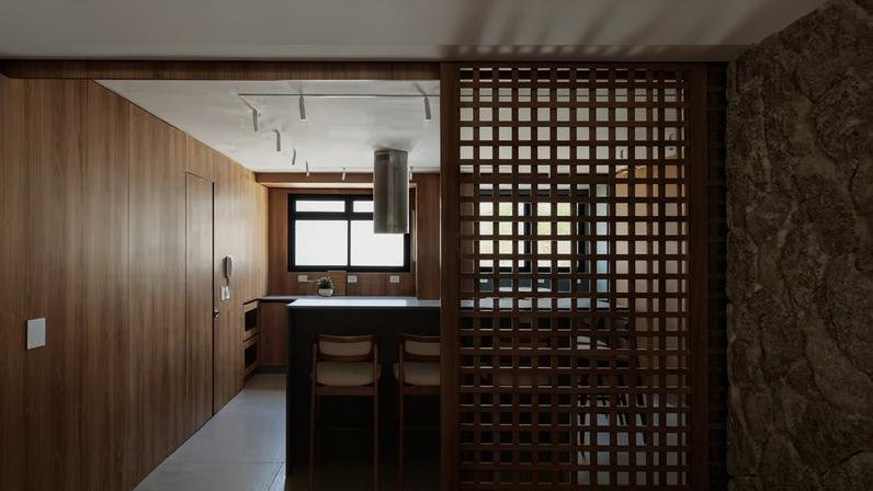 O painel de muxarabi, desenhado pelo escritório, separa a cozinha da sala de jantar sem comprometer a continuidade dos espaços. A solução garante luminosidade natural e ventilação