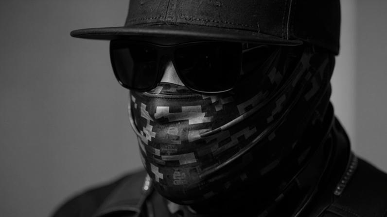 close up of a man wearing a cap, sunglasses and a face mask