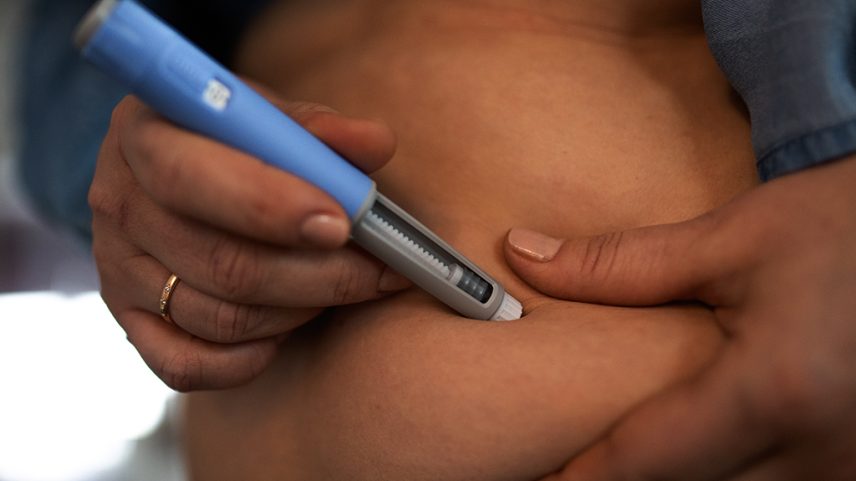 Fotografia de uma mulher aplicando caneta emagrecedora.