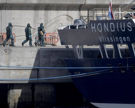 People wearing protective suits walk towards the MV Hondius as it was docked in port in Tenerife on Monday.