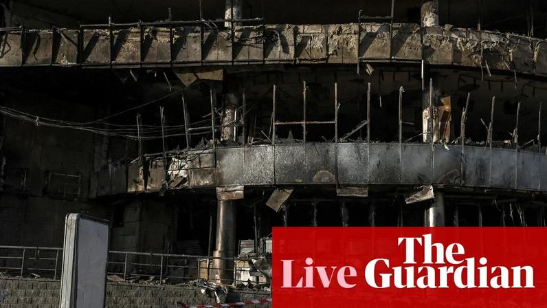 A boy plays the accordion in front of a shopping centre damaged by Russian strikes in Kyiv on Monday