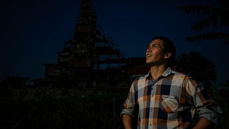 Chen Tianming standing in front of his ramshackle ten-storey house in Xingyi, in southwest Guizhou province, China.