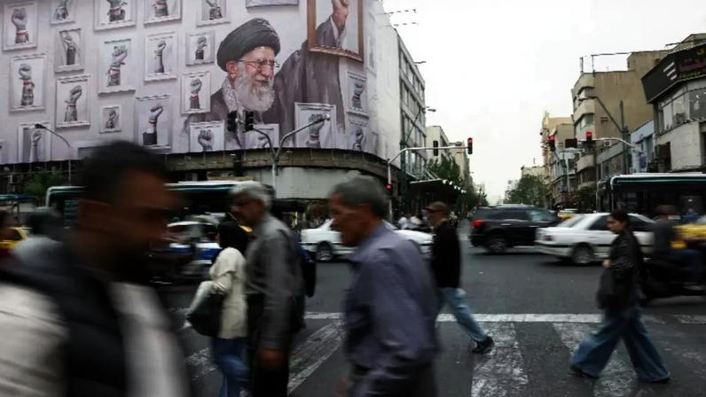 Pessoas caminham perto de um outdoor com a imagem do falecido líder supremo iraniano aiatolá Ali Khamenei, em Teerã 19 de maio de 2026 Majid Asgaripour/WANA (Agência de Notícias da Ásia Ocidental) via REUTERS