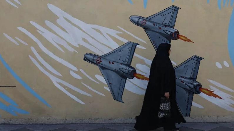 Iraniana caminha ao lado de mural anti-Israel em rua de Teerã 18 de maio de 2026 Majid Asgaripour/WANA via REUTERS