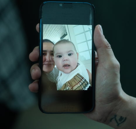 Hand holding smartphone whose screen displays an image of Keira Alexandra Kronvold and Zammi.