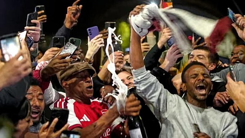 Ian Wright celebrates with Arsenal fans at the Emirates after they are crowned champions.