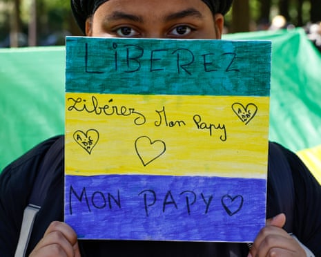 The granddaughter of the former prime minister of Gabon, Alain-Claude Bilie-By-Nze, holds a placard in the colours of the flag of Gabon reading ‘Free my grandfather’ during a demonstration in Paris on 25 April.