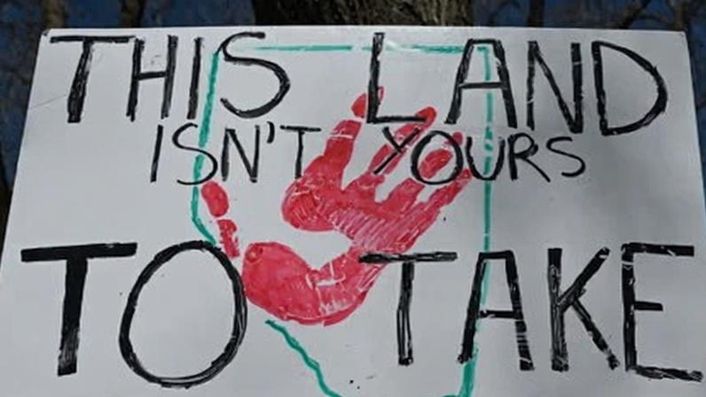 A person holds a sign outside the Alberta legislature on 3 May 2025.