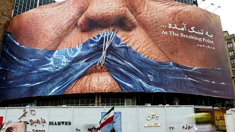 People drive past an anti-US billboard in Tehran depicting Donald Trump and the strait of Hormuz.