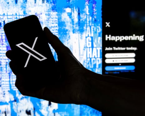A silhouetted hand holds a smartphone showing the X logo